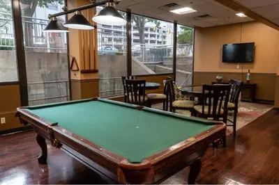 a pool table in a room with chairs and a tv at PP 514 City Chic in a Modern Studio Haven in Harrisburg