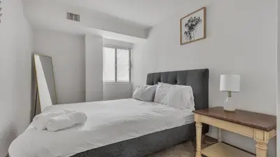 a white bedroom with a bed and a table at PP 2114 Professional 2br apt, Near Hospitals in Harrisburg