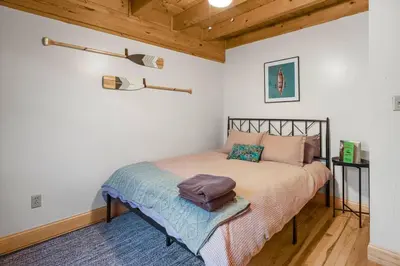 a bedroom with a bed in a room with wooden ceilings at Lakefront Log Cabin, Private Lake Access w/Peloton in Livingston Manor
