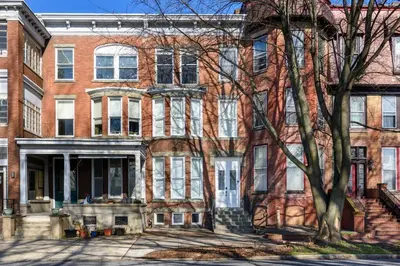 a large brick building with a tree in front of it at Flats on Front - Riverfront Gem Fast Wi-Fi 3F in Harrisburg