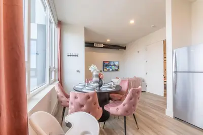 a dining room with a table and pink chairs at Rosy Retreat with NYC Views by the train, Free Parking, 3 beds, 20 Percent OFF 7 days in Newark
