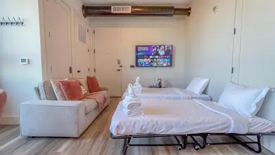a living room with two beds and a couch at Rosy Retreat with NYC Views by the train, Free Parking, 3 beds, 20 Percent OFF 7 days in Newark