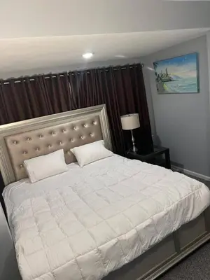 a bedroom with a large white bed with a headboard at Luxury Home in Linden