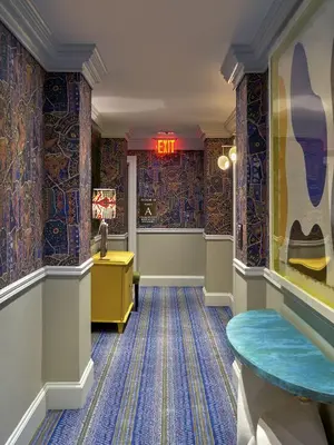 a hallway with a room with colorful wallpaper at Warren Street Hotel in New York