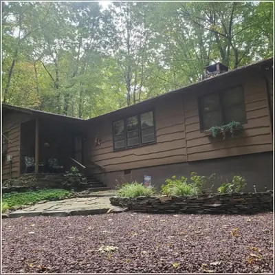 a house with a porch and a driveway at Harmony in the Woods in Lake Harmony