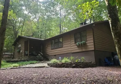 a house in the woods with a tree at Harmony in the Woods in Lake Harmony