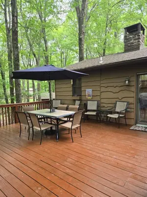 a patio with a table and chairs and an umbrella at Harmony in the Woods in Lake Harmony