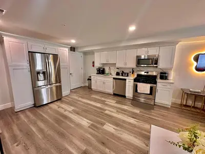 a kitchen with white cabinets and stainless steel appliances at The Modern Suite - 2BR Close to NYC in Paterson
