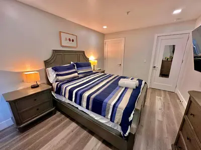 a bedroom with a bed with a blue and white striped blanket at The Modern Suite - 2BR Close to NYC in Paterson