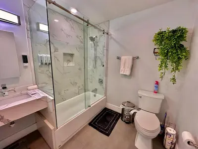 a bathroom with a shower and a toilet and a sink at The Modern Suite - 2BR Close to NYC in Paterson
