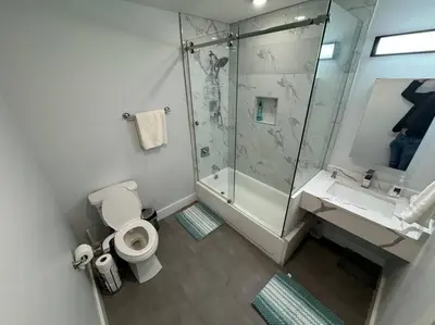a bathroom with a shower and a toilet and a sink at The Elegant Suite - 2BR with Great Amenities in Paterson