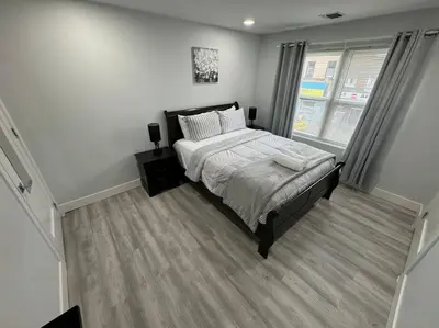 a bedroom with a large bed and a window at The Elegant Suite - 2BR with Great Amenities in Paterson