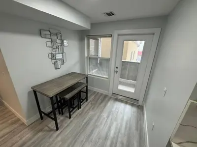 a room with a wooden table and a window at The Elegant Suite - 2BR with Great Amenities in Paterson