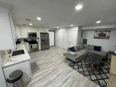 a living room with a couch and a kitchen at The Elegant Suite - 2BR with Great Amenities in Paterson