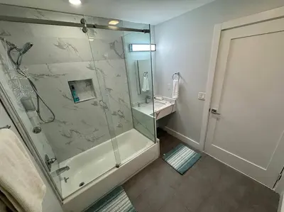 a bathroom with a glass shower and a sink at The Elegant Suite - 2BR with Great Amenities in Paterson