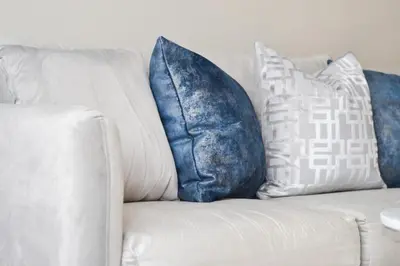 a white couch with blue and white pillows on it at Beautiful Irving two bedroom apartment in Philadelphia