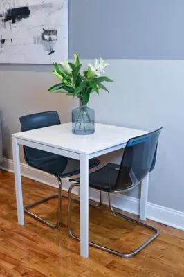 a white table with two chairs and a vase with flowers at Beautiful Irving two bedroom apartment in Philadelphia