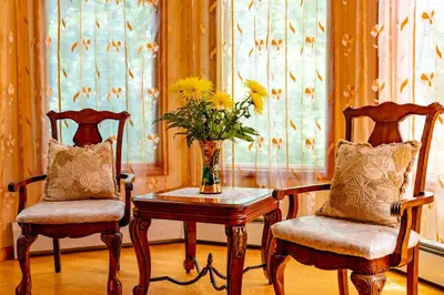 two chairs and a table with a vase of flowers at Cherry Valley Manor in Stroudsburg