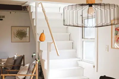 a white staircase in a living room with chairs at renovatedhot tubnear skiingtubingcozy & chic in Monticello