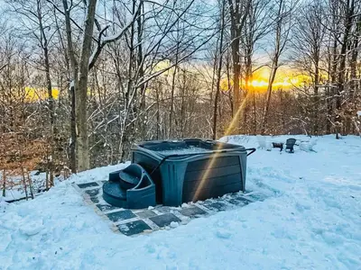 a trash can in the snow with the sun in the background at renovatedhot tubnear skiingtubingcozy & chic in Monticello