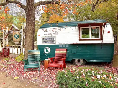 a green and white food truck parked next to chairs at renovatedhot tubnear skiingtubingcozy & chic in Monticello