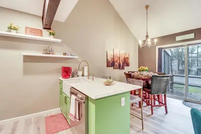 a kitchen with green cabinets and a dining room at Cozy Cabin with Deck Less Than 1 Mi to Jack Frost Resort! in White Haven