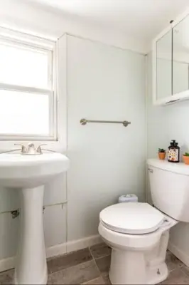 a white bathroom with a toilet and a sink at room with a private shower in Arlington