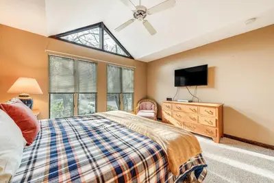 a bedroom with a bed and a flat screen tv at Community Beach Access Lake Harmony Townhome in Lake Harmony