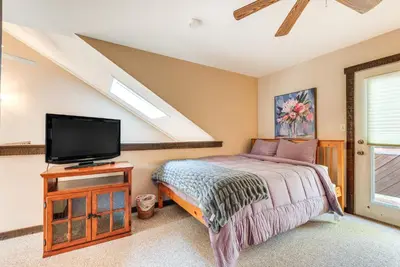 a bedroom with a bed and a flat screen tv at Community Beach Access Lake Harmony Townhome in Lake Harmony