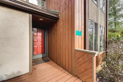a wooden porch with a red door on a house at Community Beach Access Lake Harmony Townhome in Lake Harmony
