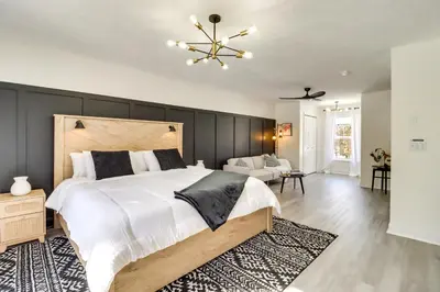 a bedroom with a large bed with a black wall at 9 Mi to Camelback! Home with Hot Tub and Fire Pit in Long Pond