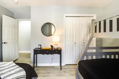 a bedroom with a bed and a table with a mirror at 9 Mi to Camelback! Home with Hot Tub and Fire Pit in Long Pond