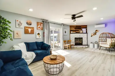 a living room with a blue couch and a fireplace at 9 Mi to Camelback! Home with Hot Tub and Fire Pit in Long Pond