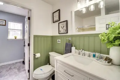a bathroom with a sink and a toilet and a mirror at 9 Mi to Camelback! Home with Hot Tub and Fire Pit in Long Pond