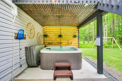 a jacuzzi tub sitting inside of a building at 9 Mi to Camelback! Home with Hot Tub and Fire Pit in Long Pond