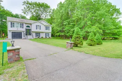 a white house with trees and a driveway at 9 Mi to Camelback! Home with Hot Tub and Fire Pit in Long Pond