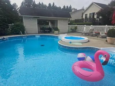 a swimming pool with a pink flamingo in the water at Escape to the Catskills in Liberty