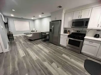 a kitchen with white cabinets and stainless steel appliances at The Lovely Suite - 1BR close to NYC in Paterson