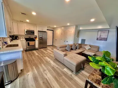 a large living room with a couch and a kitchen at The Classy Suite - 2BR with Free Parking in Paterson