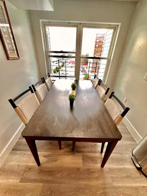 a wooden table in a room with a large window at The Classy Suite - 2BR with Free Parking in Paterson
