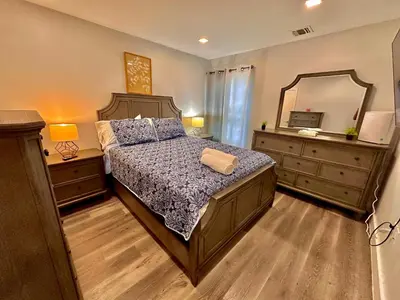 a bedroom with a bed and a large mirror at The Classy Suite - 2BR with Free Parking in Paterson