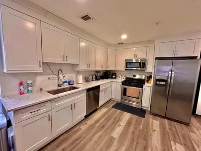 a kitchen with white cabinets and stainless steel appliances at The Classy Suite - 2BR with Free Parking in Paterson
