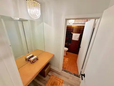 a bathroom with a wooden table and a toilet at Ultimate Luxury Villa - Pool, Sauna, Hot Tub & More in Paterson