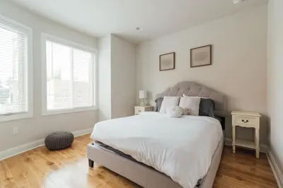 a bedroom with a large bed and two windows at Roof Deck Oasis near PENN and CHOP in Philadelphia