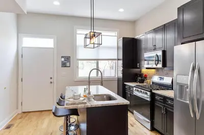 a kitchen with stainless steel appliances and a sink at Roof Deck Oasis near PENN and CHOP in Philadelphia