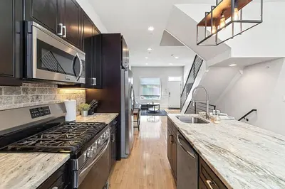 a kitchen with a stove and a sink at Roof Deck Oasis near PENN and CHOP in Philadelphia
