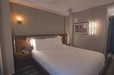 a bedroom with a white bed and a green wall at Hotel Edison Times Square in New York