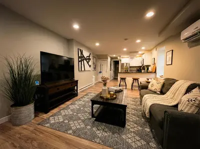 a living room with a couch and a flat screen tv at Boardwalk- large modern unit with King bed fast WIFI free coffee and easy parking in Wilmington
