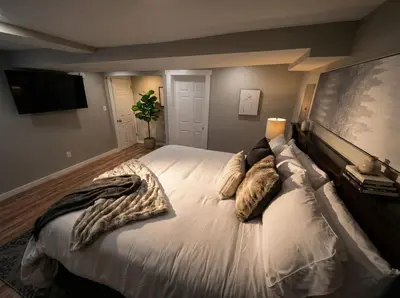 a bedroom with a large bed with pillows on it at Boardwalk- large modern unit with King bed fast WIFI free coffee and easy parking in Wilmington
