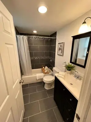 a bathroom with a toilet and a shower and a sink at Boardwalk- large modern unit with King bed fast WIFI free coffee and easy parking in Wilmington